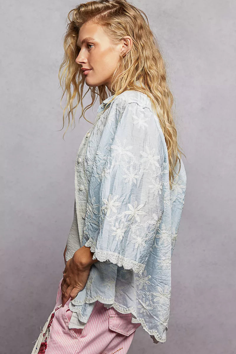 Light blue sheer lace blouse with white floral embroidery and scalloped hem