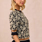 BiBi Textured Rose Knit Top with black and cream floral print, ruffled cuffs and hem