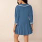Blue pleated sailor dress with Peter Pan collar, tie front, and white trim