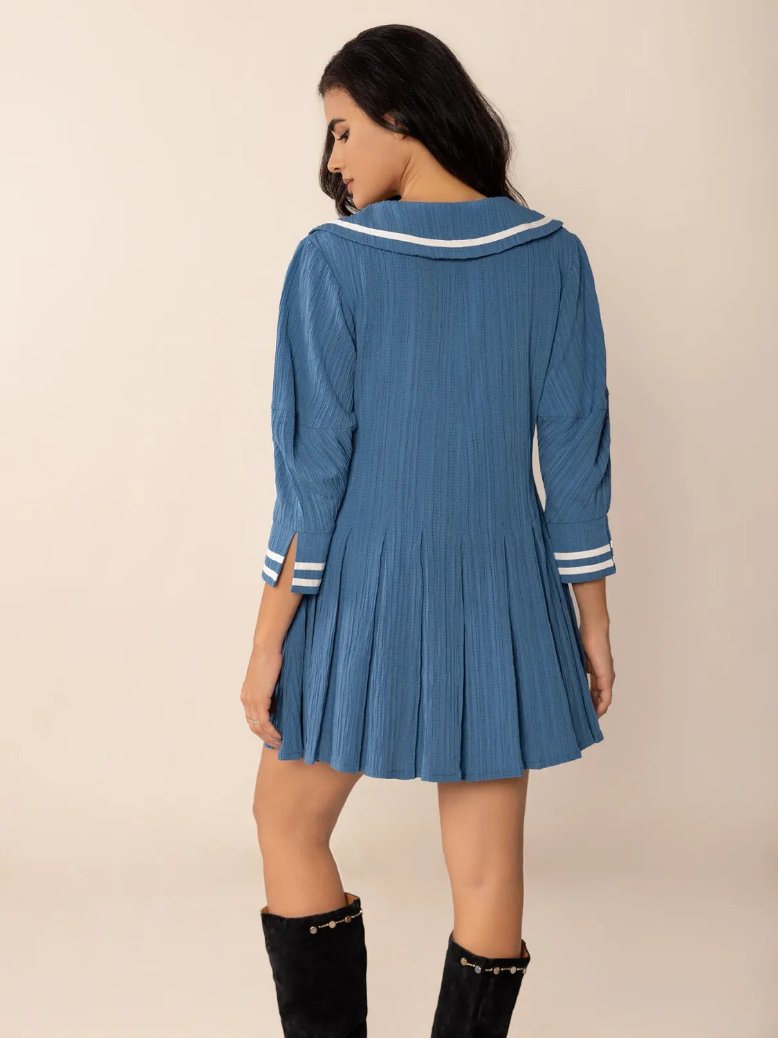 Blue pleated sailor dress with Peter Pan collar, tie front, and white trim