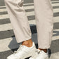 White leather sneakers with minimalist design on Daverri Fashions pants