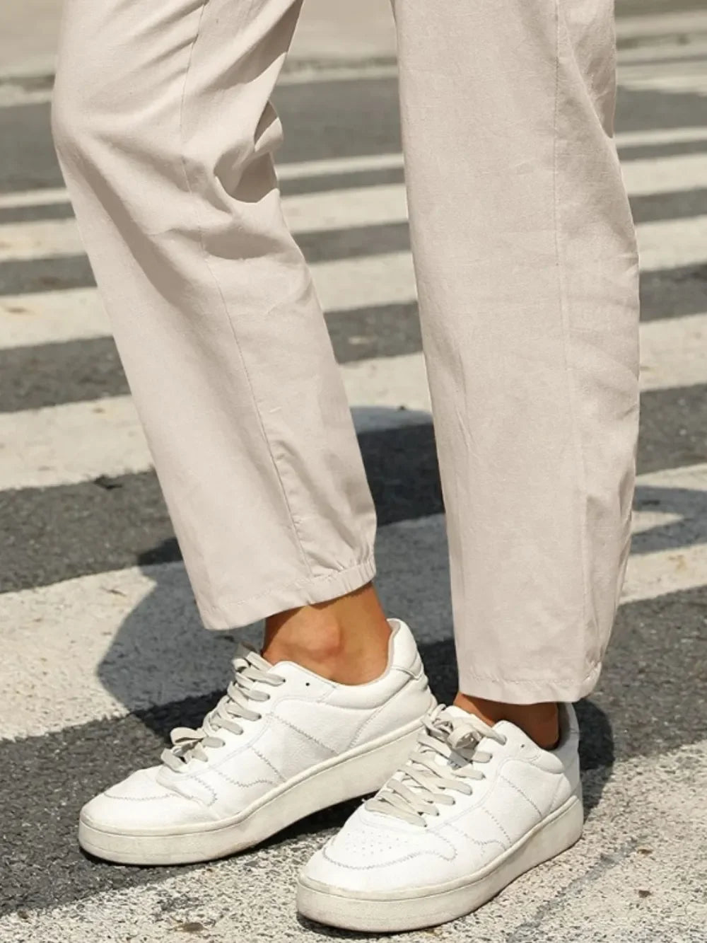 White leather sneakers with minimalist design on Daverri Fashions pants