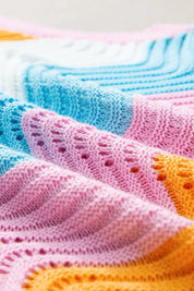 Pastel rainbow knit blanket with lace patterns in Daverri Fashions vest