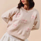 Cream-colored SO ME knit sweater with pink embroidered bows