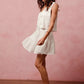 White eyelet lace sleeveless dress with tiered skirt and v-neckline