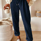 Navy blue corduroy tapered pants with rolled cuffs by Daverri Fashions