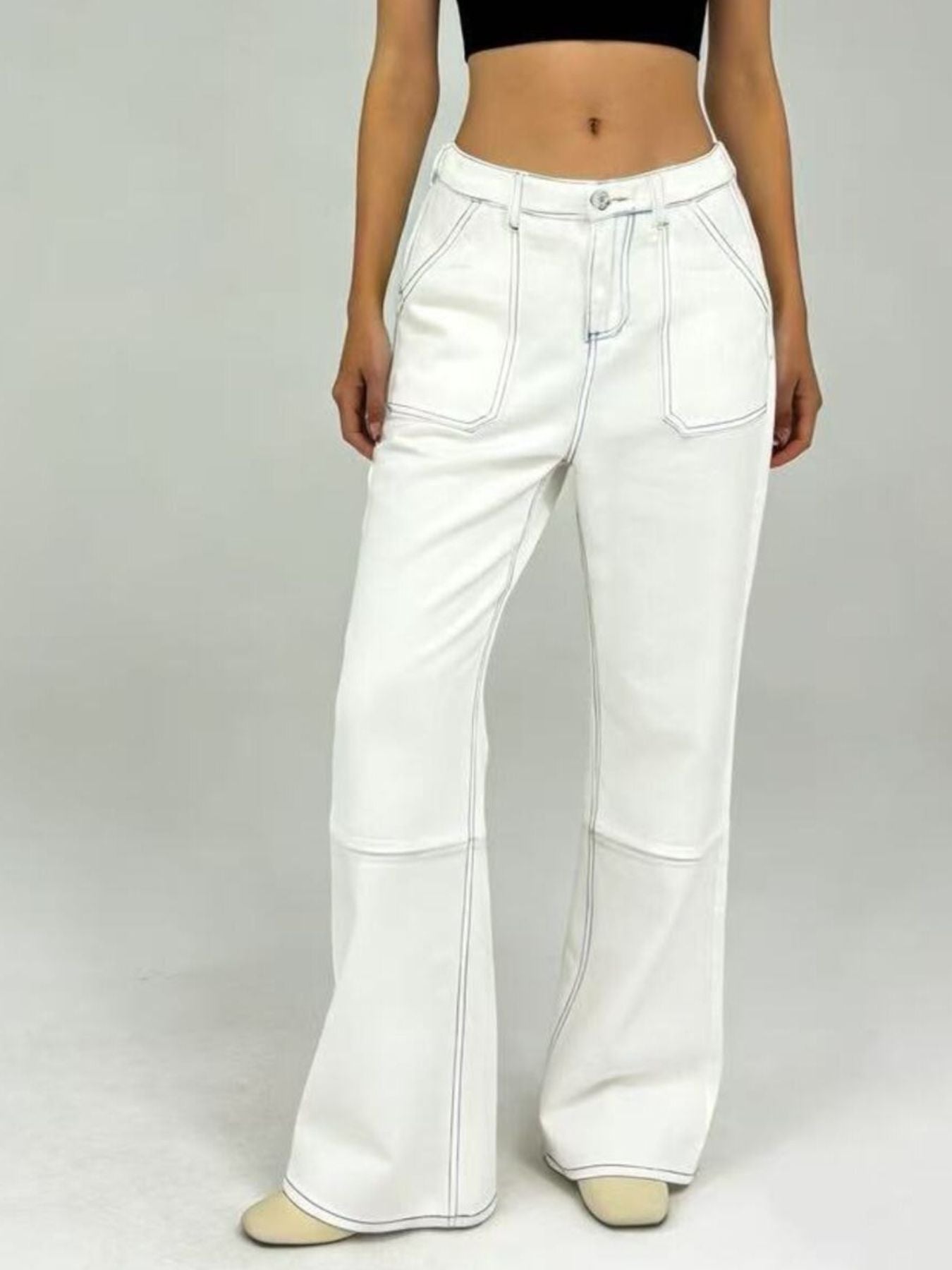 White wide-leg jeans with black contrast stitching and flared silhouette