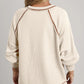 Cream-colored ribbed knit V-neck pullover with brown exposed seams