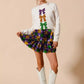 White sequined sweater with purple, gold, green bow accents for Mardi Gras