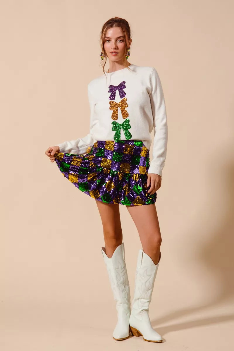 White sequined sweater with purple, gold, green bow accents for Mardi Gras