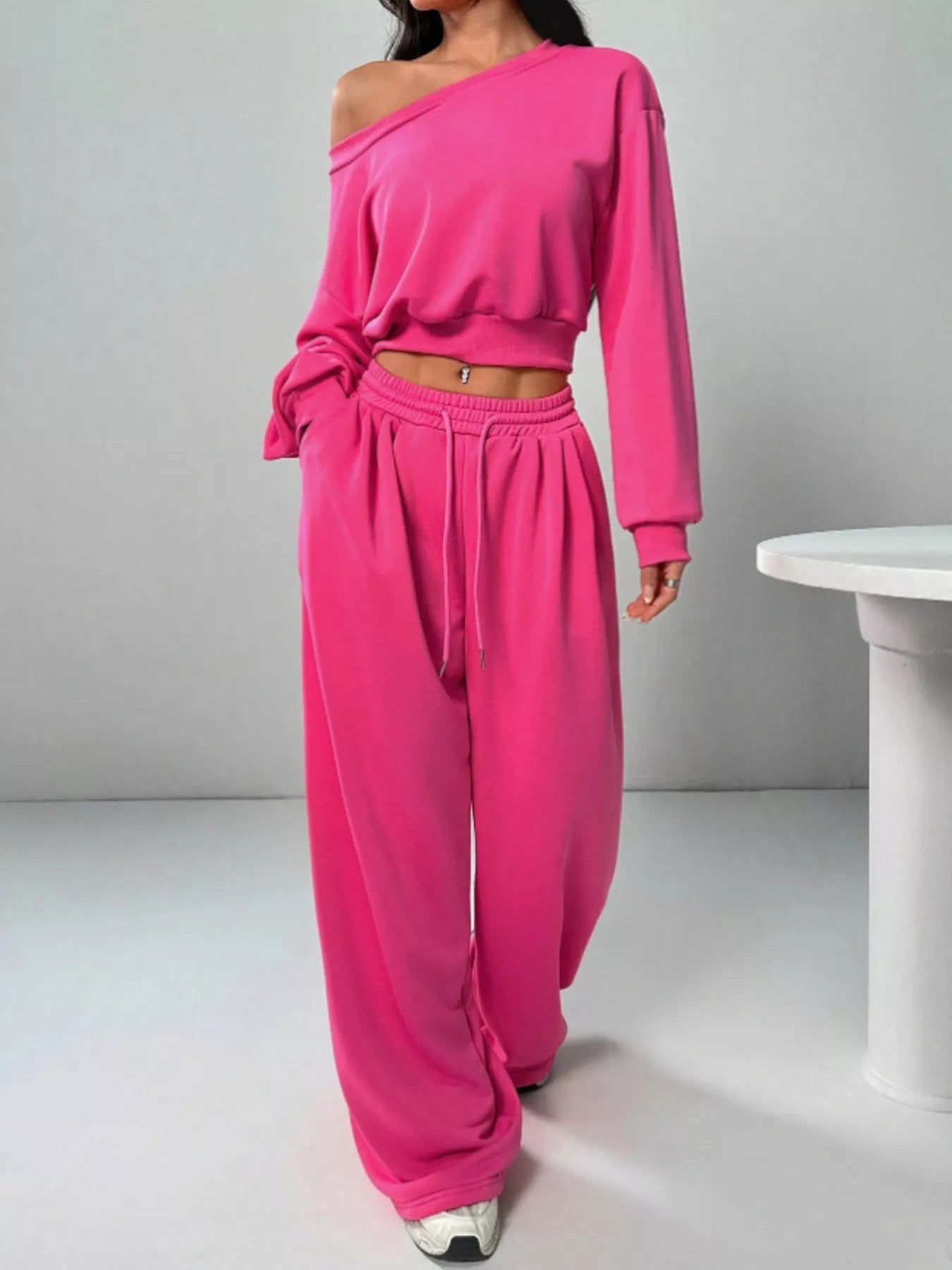 Bright pink one-shoulder cropped sweatshirt with matching wide-leg joggers