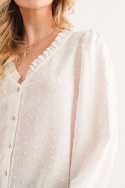 White ruffled polka dot blouse with gold necklace