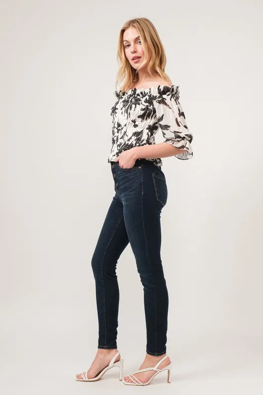 Black skinny jeans with And The Why smocked floral off-shoulder top and clear heels