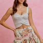 Light gray knitted crop top with twisted front on SO ME floral skirt