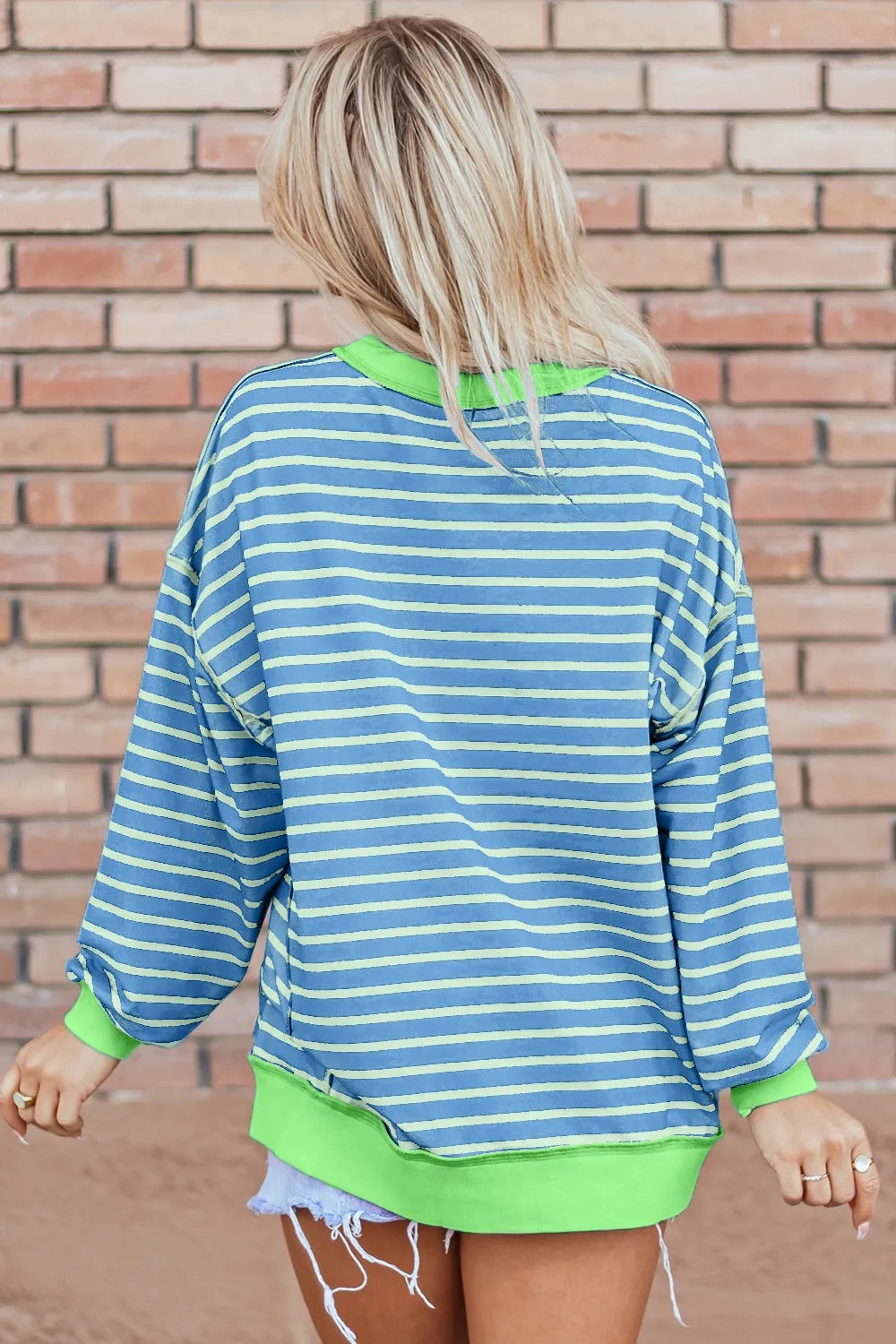 Blue and light green striped high-low long sleeve sweatshirt with neon green ribbed trim