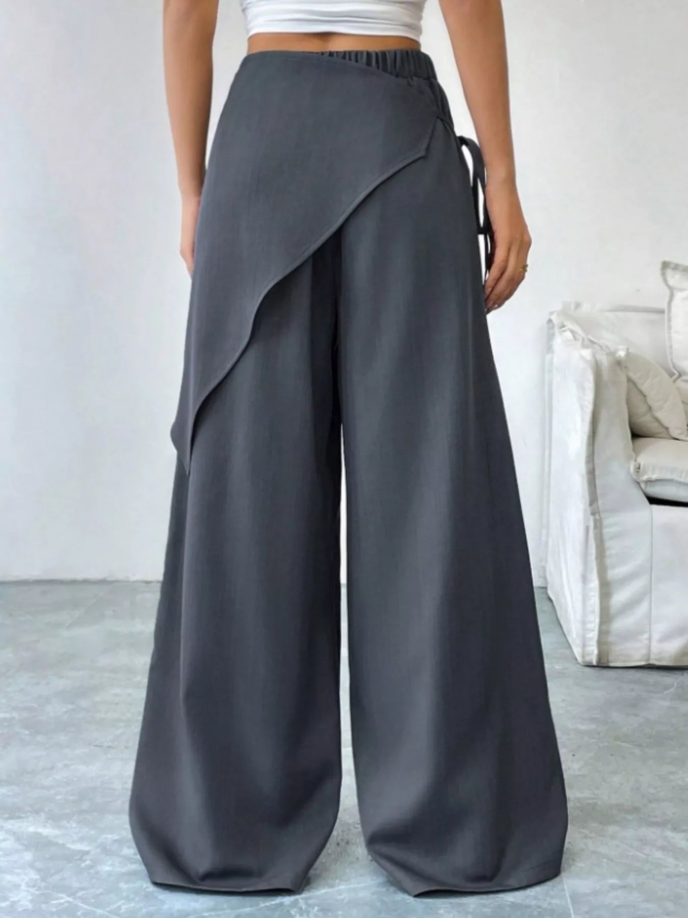 Daverri wrap-front wide-leg pants in dark gray with draped asymmetrical design and elastic waistband