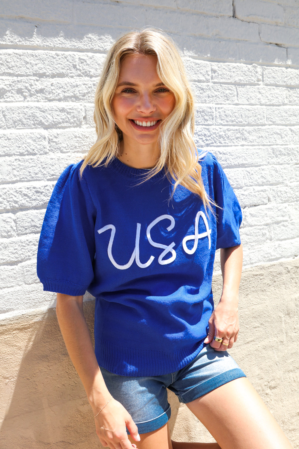 Patriotic USA blue knit puff sleeve sweater with white cursive graphic