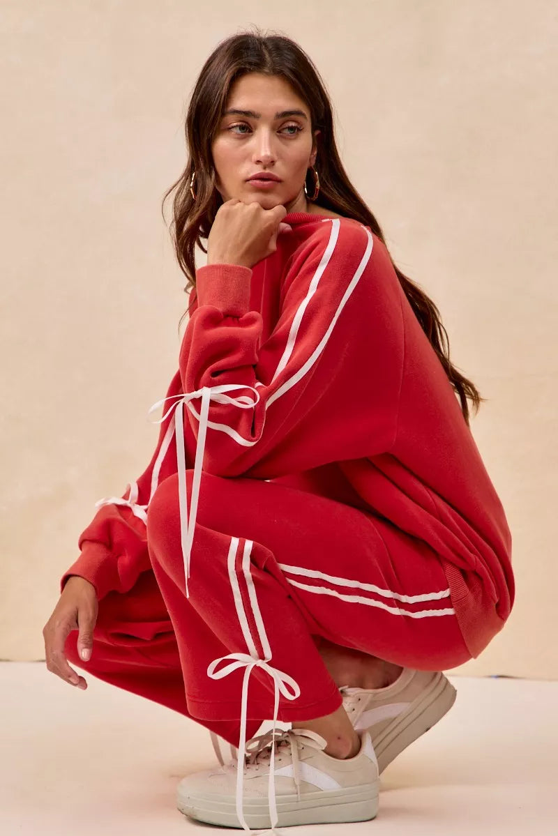 Red oversized hoodie with white stripes, drawstrings, and BiBi bow details
