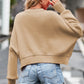 Beige cropped knit sweater with round neck, drop shoulders, and ribbed cuffs