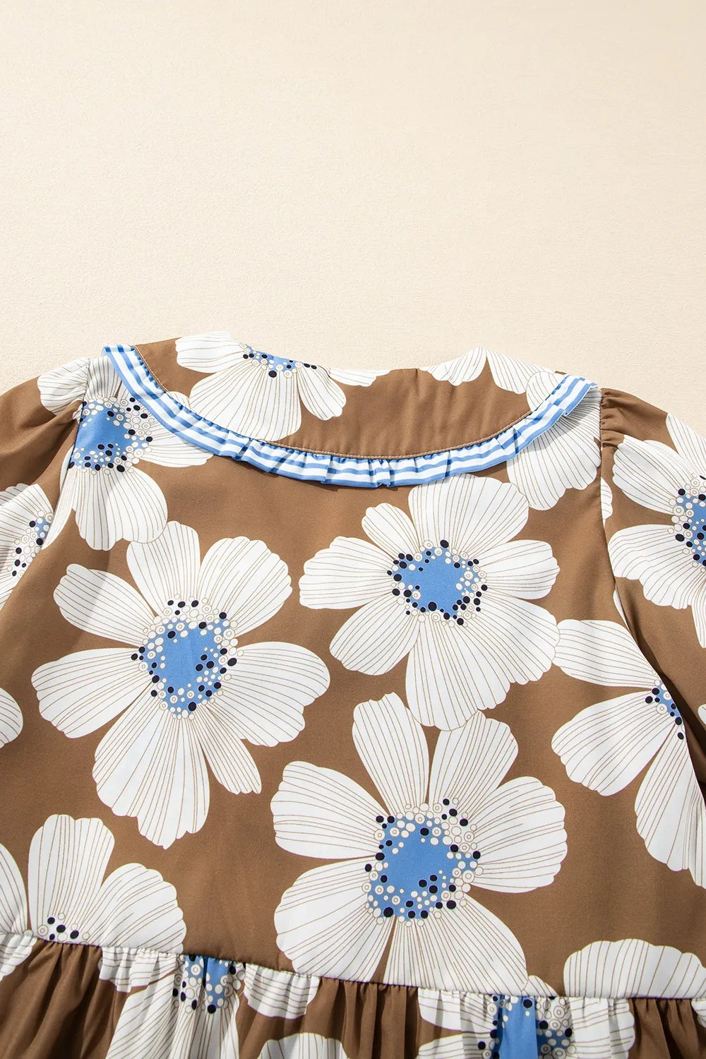Brown floral print blouse with striped tie sleeves and ruffled neckline