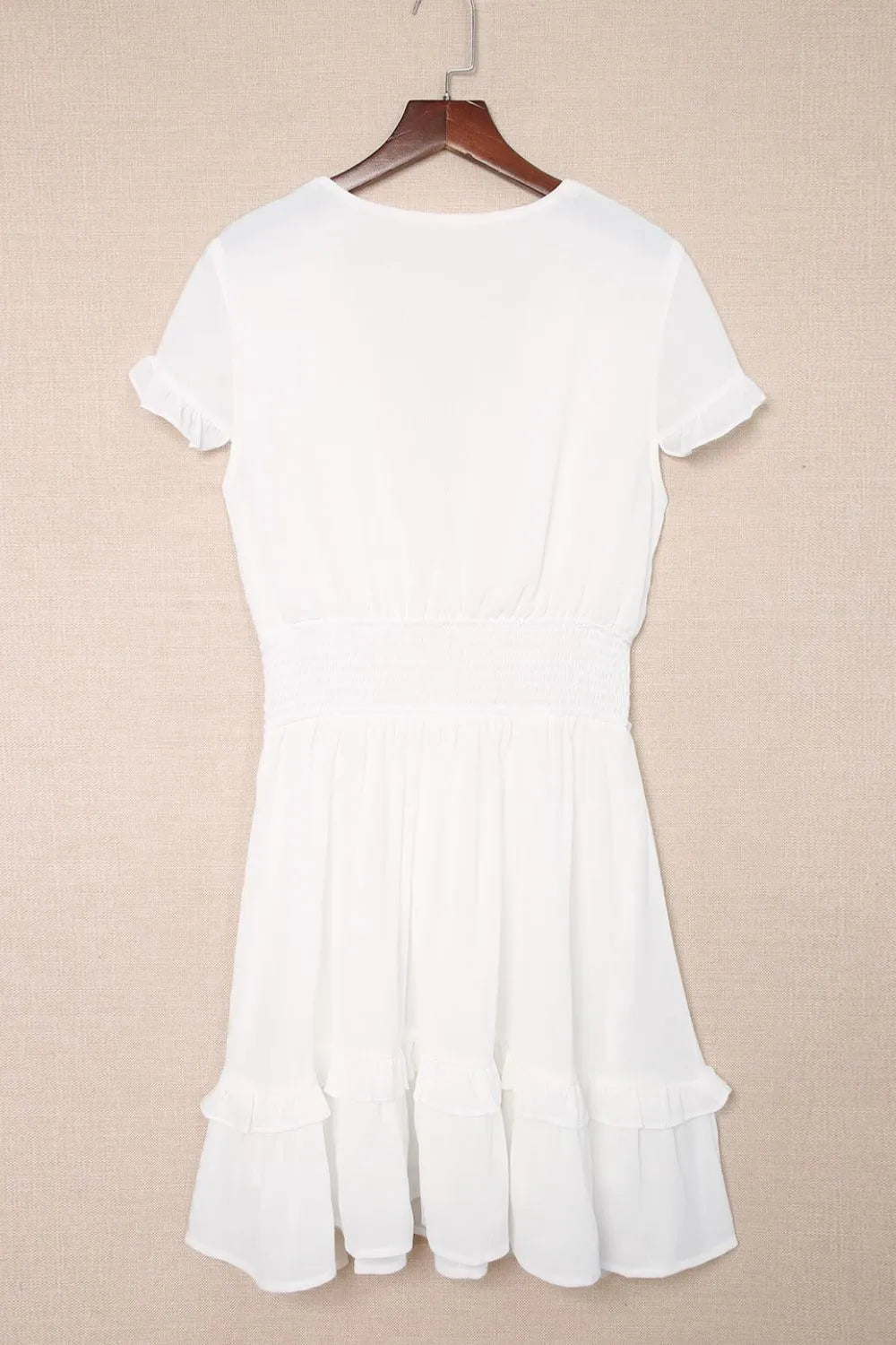 White short-sleeved A-line tie-front mini dress with smocked waist, flared skirt and ruffled hem