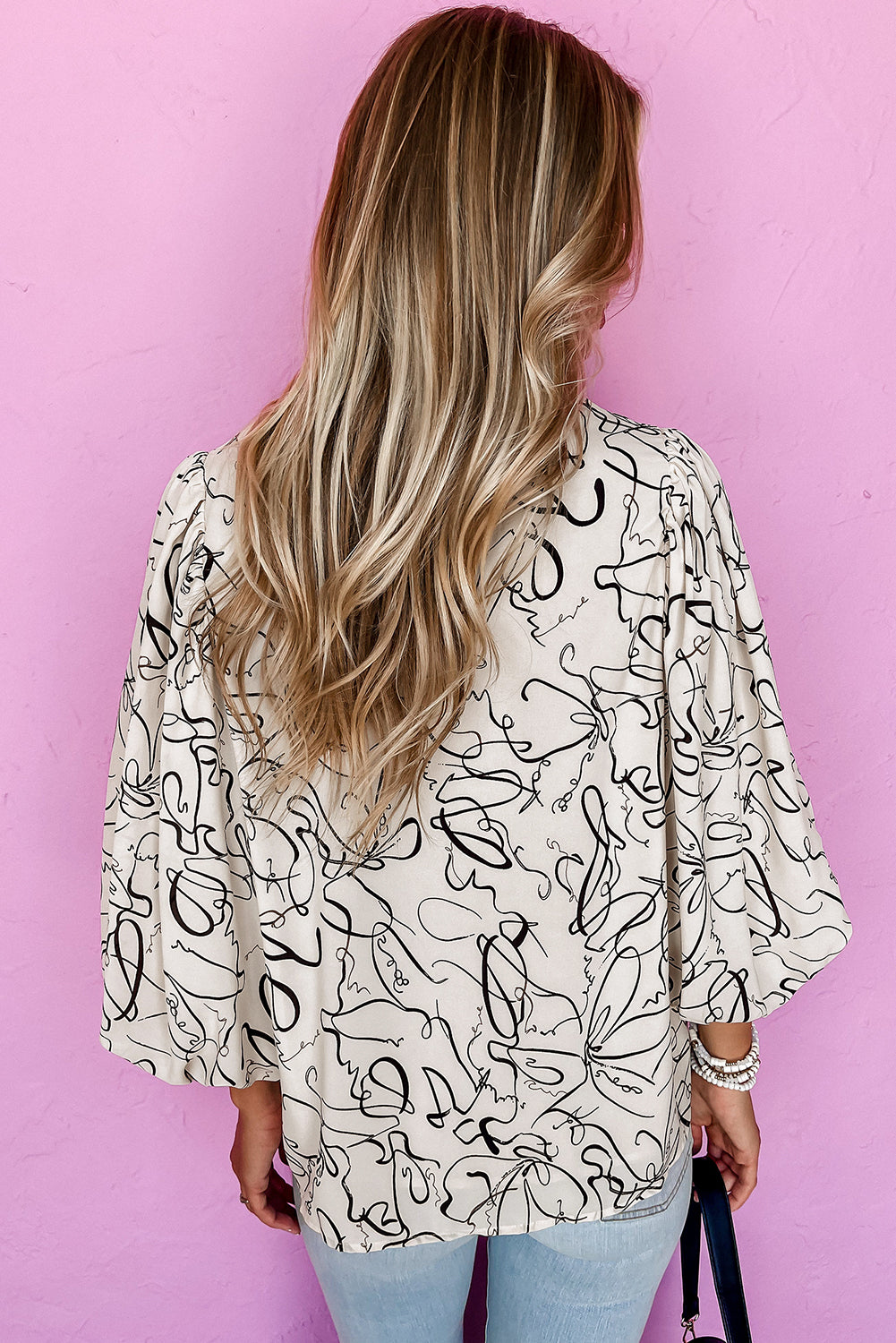 Cream-colored abstract line art blouse with bell sleeves