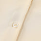 Cream-colored womens 3/4 sleeve oversized button-up shirt with pearl buttons