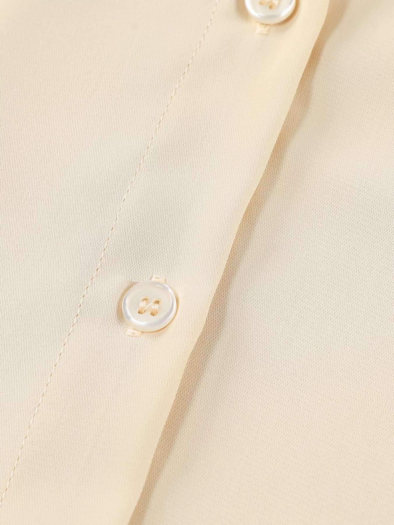 Cream-colored womens 3/4 sleeve oversized button-up shirt with pearl buttons