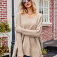 Beige v-neck oversized knit sweater with ribbed cuffs and hem