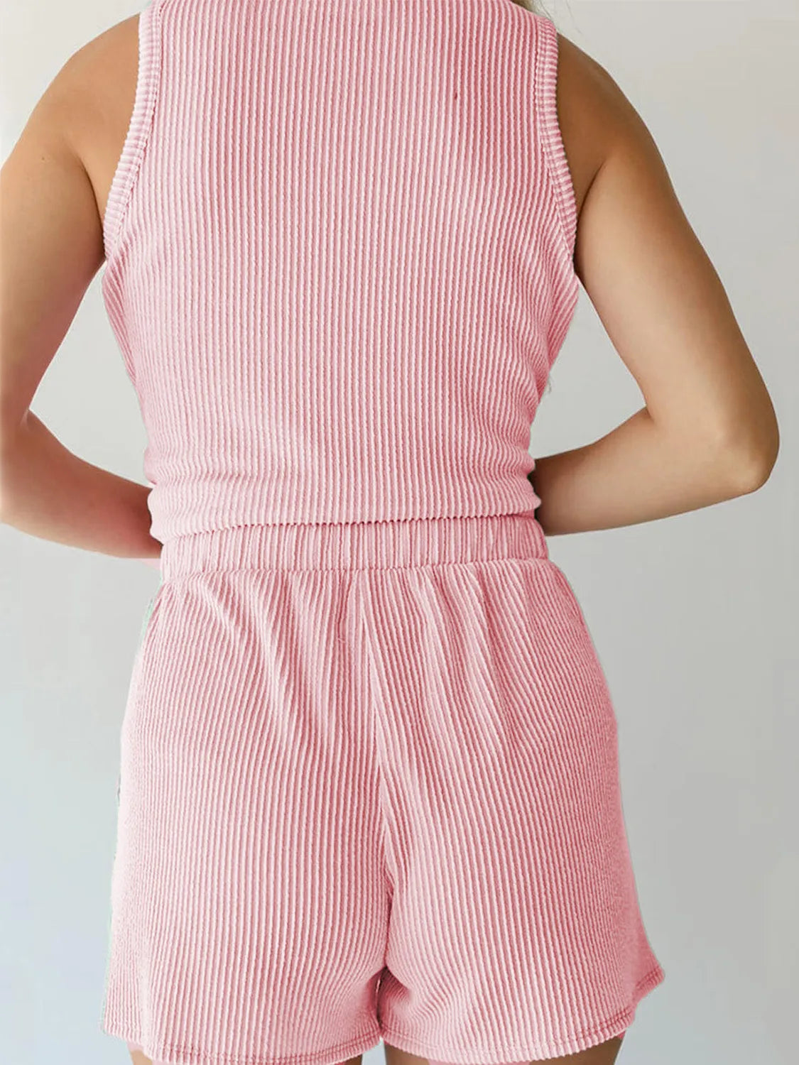 Pink corduroy sleeveless romper with ribbed texture and elastic waistband