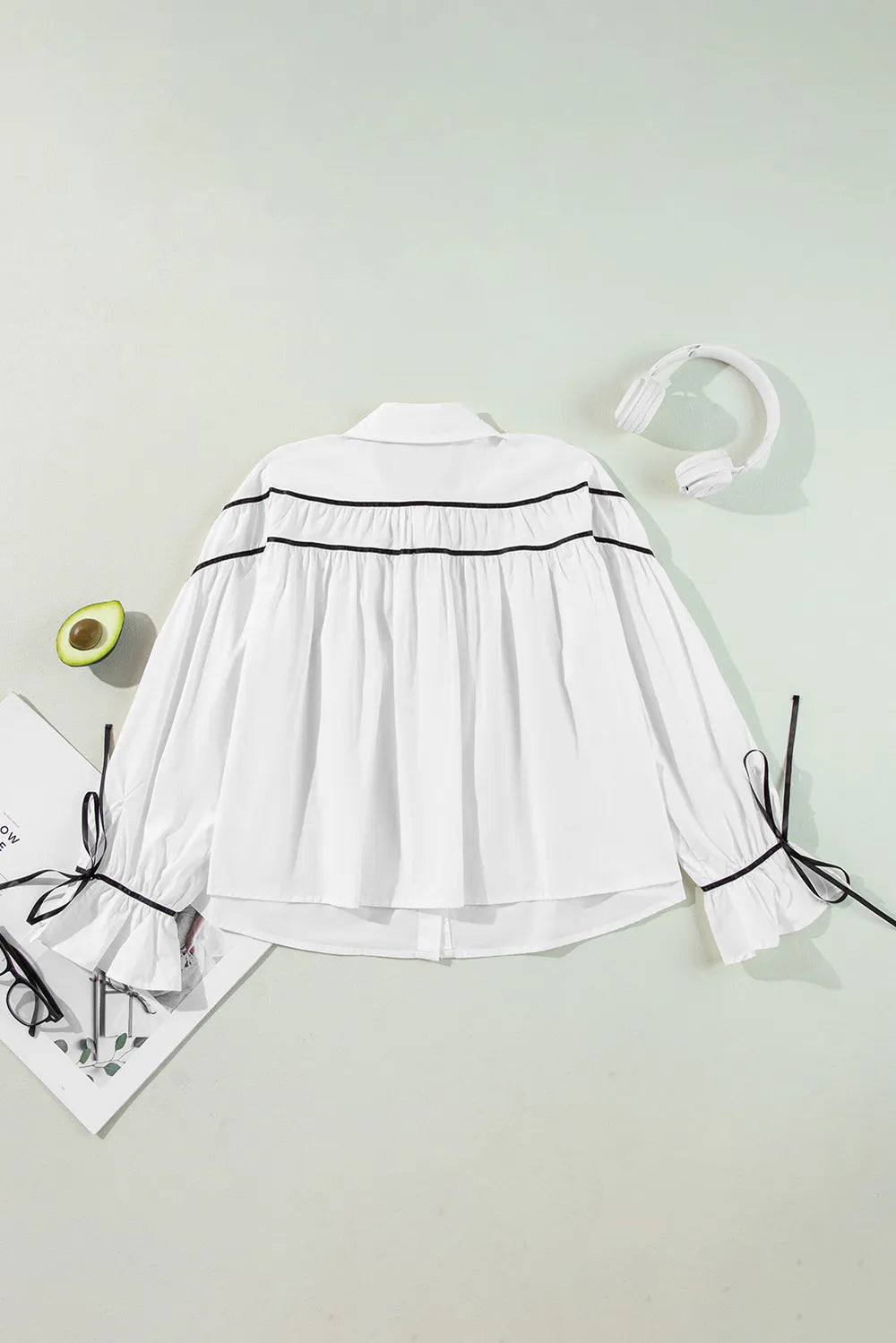White ribbon bowtie collared blouse with black trim and ruffled sleeves