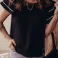 Black short-sleeved textured blouse with white piping and ruffles