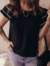Black short-sleeved textured blouse with white piping and ruffles