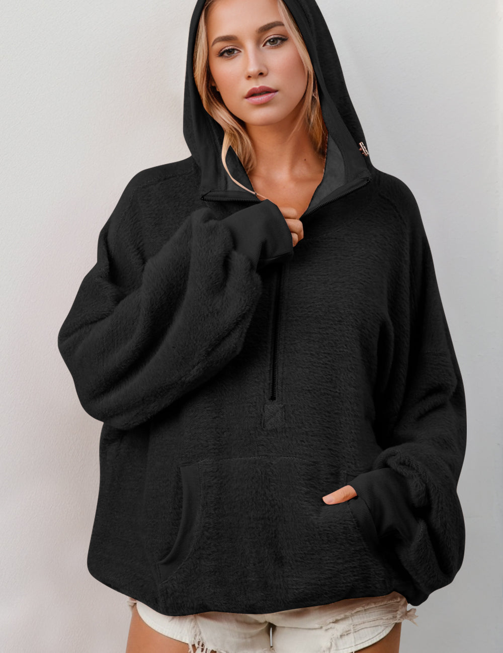 Black oversized hoodie with textured fabric, ribbed cuffs, kangaroo pocket