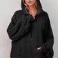 Black oversized hoodie with textured fabric, ribbed cuffs, kangaroo pocket
