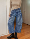 Wide-leg blue denim jeans with a faded, distressed look and visible stitching.
