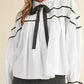 White ribbon bowtie collared blouse with black ruffle trim