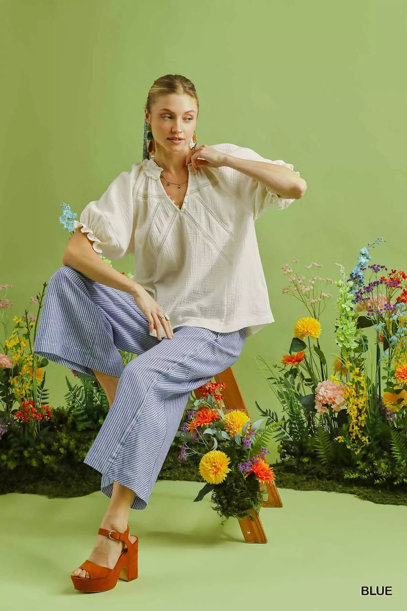 Woman in Umgee Linen Blend Striped Wide Leg Pants and white ruffled blouse