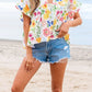 Floral boxy fit ruffled short sleeve blouse with vibrant blossoms