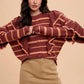 Maroon and tan striped knit cardigan with ruffled sleeves on khaki mini skirt