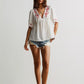 White embroidered floral V-neck blouse with red patterns and short flutter sleeves