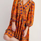 Vibrant orange bohemian floral print long sleeve mini dress with v-neckline