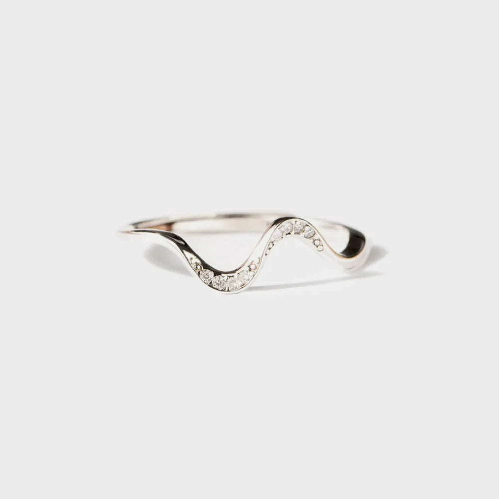 Silver ring with a wavy design on a white background