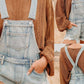 Distressed denim overalls shorts in light-wash with frayed hem and adjustable straps