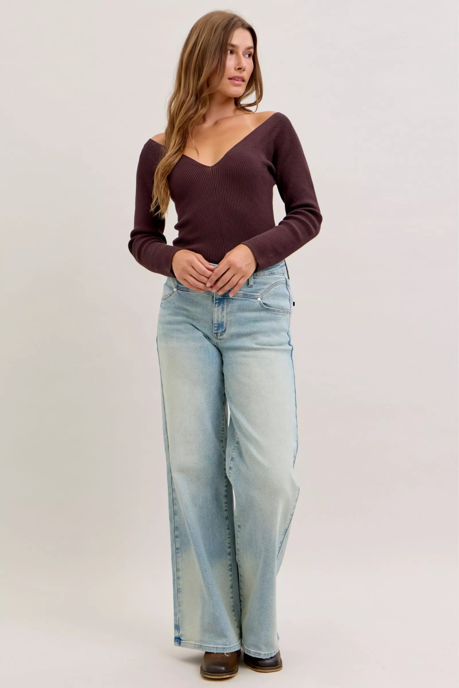 A pair of light-wash, wide-leg denim jeans with a classic five-pocket design and subtle fading along the thighs.