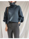 Dark blue ribbed knit oversized turtleneck sweater with voluminous sleeves