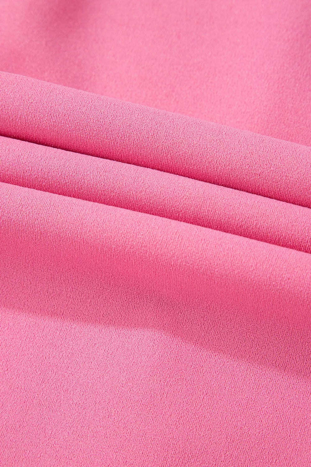 Vibrant pink high-waisted bootcut pants with soft smooth fabric folds