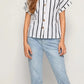 Woman in bold black and white striped button-up short sleeve shirt