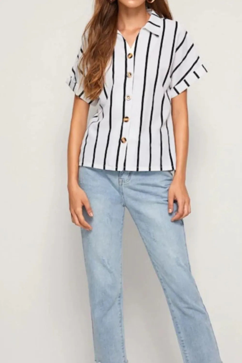 Woman in bold black and white striped button-up short sleeve shirt