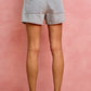 Back view of SO ME mid-rise denim shorts with frayed hem and back pockets